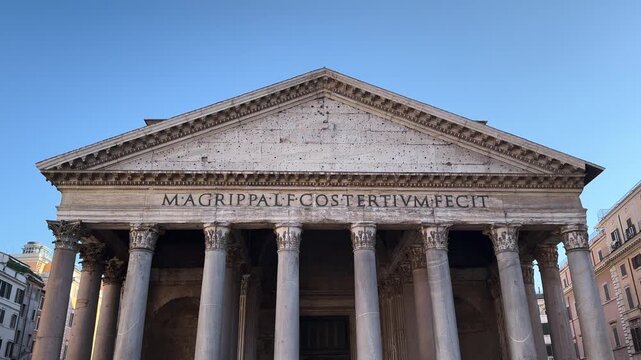 Front view of the Pantheon portico with Corinthian columns and pediment under a blue sky, Rome, Italy