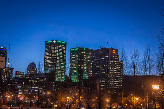 MONTREAL, CANADA - DECEMBER 29, 2016: Montreal CBD skyline at night, with office towers, Desjardins, Quebecor and Courtyard Marriott signage above a park in the downtown business district in Canada.