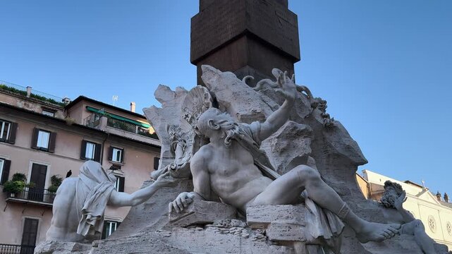 Obelisk rising above sculpted marble river gods and rock of the Fountain of the Four Rivers, Piazza Navona, Rome, Italy