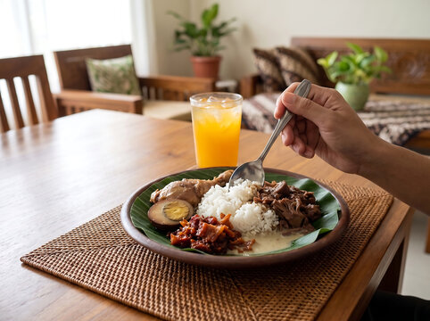 Close up of a person enjoying a traditional meal of Gudeg Yogyakarta