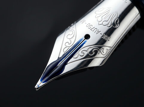 Fountain pen nib with blue ink close-up, luxury writing instrument