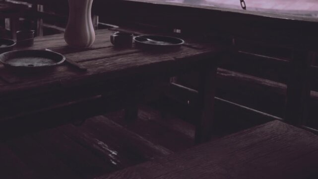 A cozy wooden table inside a rustic eatery features simple dishes and a pitcher, bathed in soft light. The atmosphere feels calm and inviting, perfect for sharing stories over food.