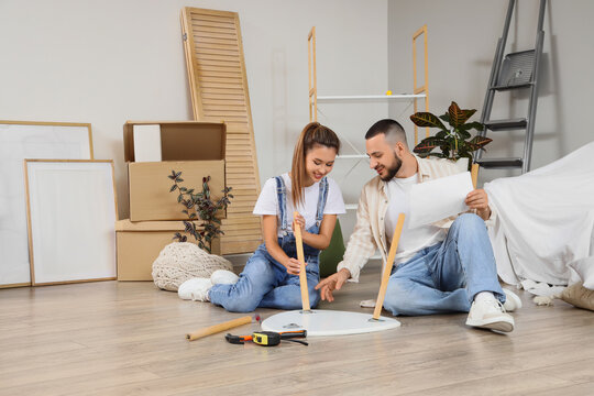 Home improvement and renovation, young couple assembling furniture in new apartment with cardboard boxes and tools for interior design project