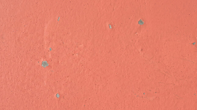 Coral pink painted wall surface with peeling paint
