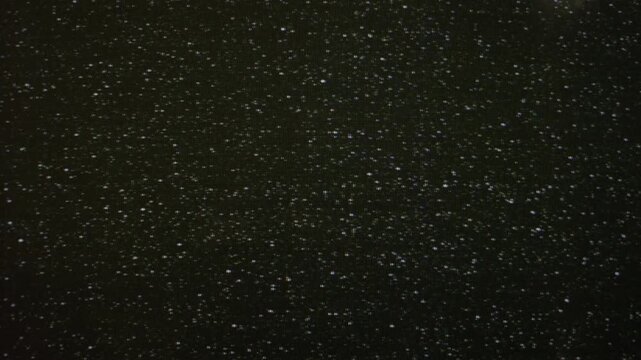 Retro television noise filling a dark screen with rolling grain