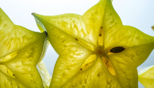 Close-up backlit translucent starfruit slices showing seeds and pulp