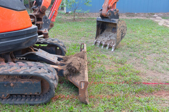 Heavy excavator digs trench for drainage pipe at Construccion site during excavation work.