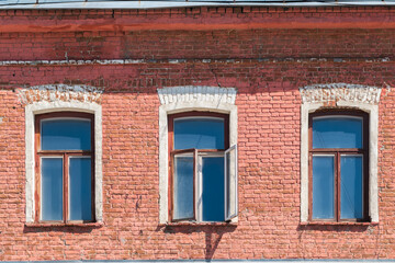 Three windows of the old mansion 19 century with brown bricks wall © Dmitrii Potashkin