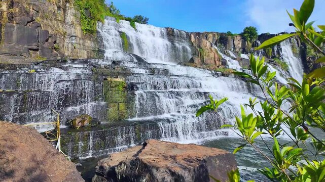 Pongour Waterfall in Lam Dong Province, Vietnam, captured in a beautiful morning timelapse. Water cascades down spectacular multi-tiered rock formations, creating a magnificent natural landscape