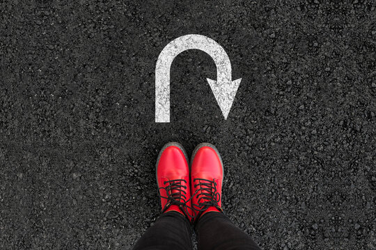 Business Pivot and Rethinking Strategy: A Woman in Red Boots Standing at a Strategic U-Turn Junction.