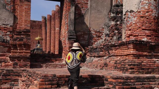Female Traveler Visiting Vihara Ruins of Wat Thammikarat Ancient Buddhist Temple, Ayutthaya Historical Park, Thailand