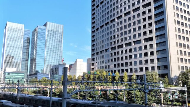 Express train passing in front of modern skyscrapers under blue sky in Tokyo Japan