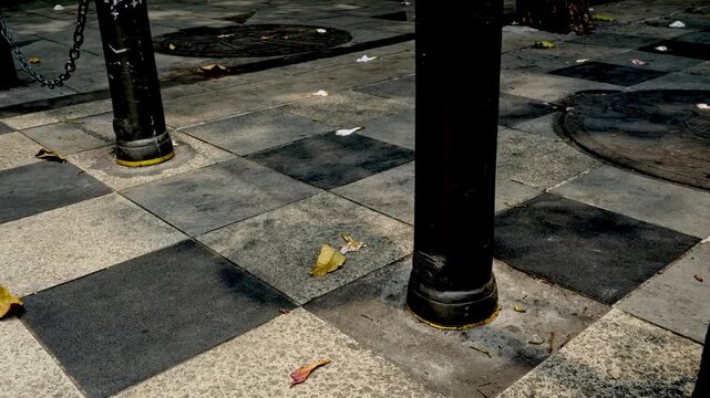 Black Steel Bollards With Chains On Modern Checkered Paving Outside An Urban Office Building Entrance