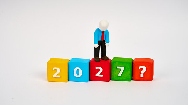 Sad businessman on colorful 2027 blocks with question mark
