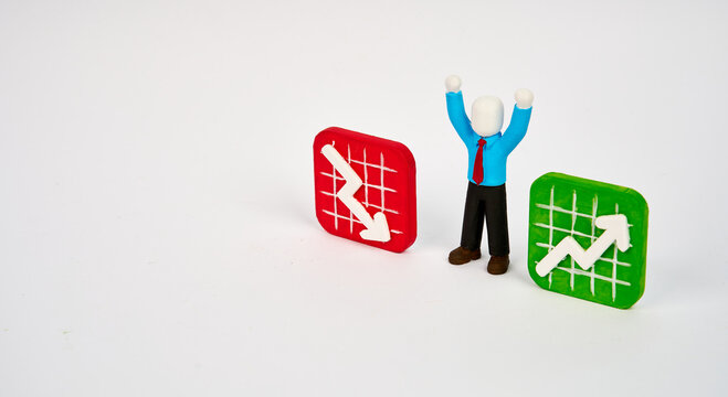 Businessman celebrating between rising and falling charts