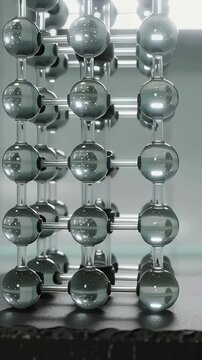 Vertical video: Panning cam showing glass beads and rods on base, backlit shifting glow for depth