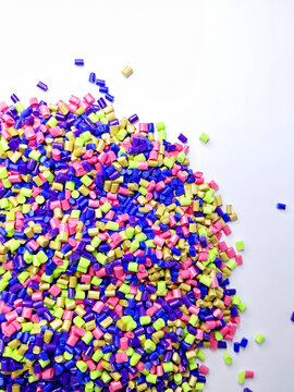 Masterbatch granules, industrial plastic manufacturing, colorful polymers arranged in rows, forming a rainbow-like shape, as a background for the design of a product catalog for an industrial plastic