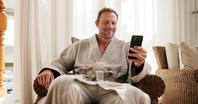 Spa, phone and mature man with smile for hospitality rating, social media and check in at lodge. Happy person, technology and relax in waiting room with mobile app, luxury accommodation and bathrobe