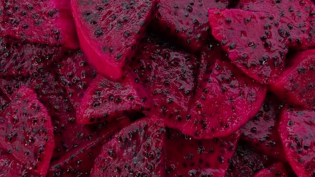 Closeup of red dragon fruit slices rotation top view.