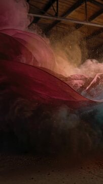 Vertical video: Waving pink-teal fabric and powder mixing after gold burst for art in warehouse