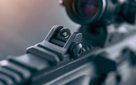 Macro view of rifle iron sights, metal barrel. Close up detail of firearm mechanism, optic gear. Black tactical weapon shows precision engineering, sharp craftsmanship. Pro shooting equipment