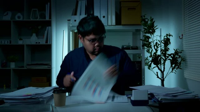Frustrated office worker reviewing business documents and expressing dissatisfaction with report results at night