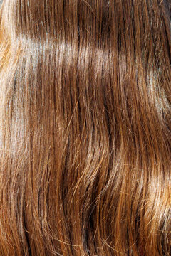 Smooth, glossy brown hair flows softly under bright light