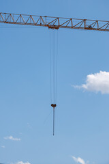 Crane arm hangs against blue sky © schankz