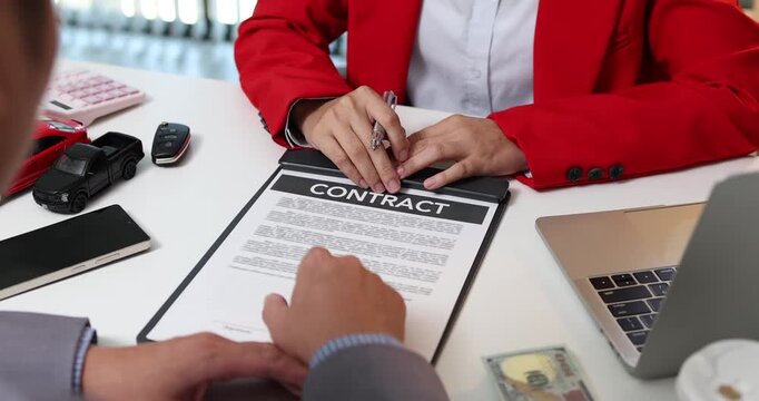 Professional car sales negotiation and vehicle purchase agreement between a salesperson and a customer, focusing on contract signing, financial discussions and completing the process of buying a car.