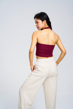Asian model in burgundy halter tank top and white wide-leg pants