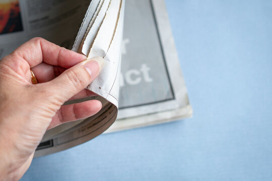 Reading newspaper, close up.
