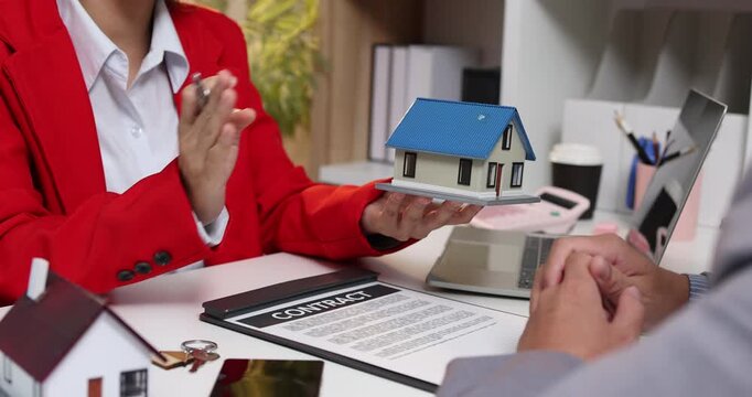Real estate sales consultation between a property agent and a potential buyer, focusing on house selection, contract negotiation and financial planning to support informed homeownership decisions.