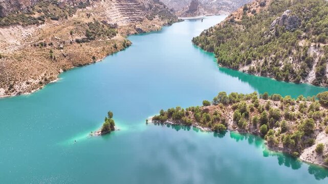 Aerial cruises down the main channel of Spain's famous Lake Portillo flying between steep forest covered hills and the remains of an old terraced quarry. Castril Granada Spain