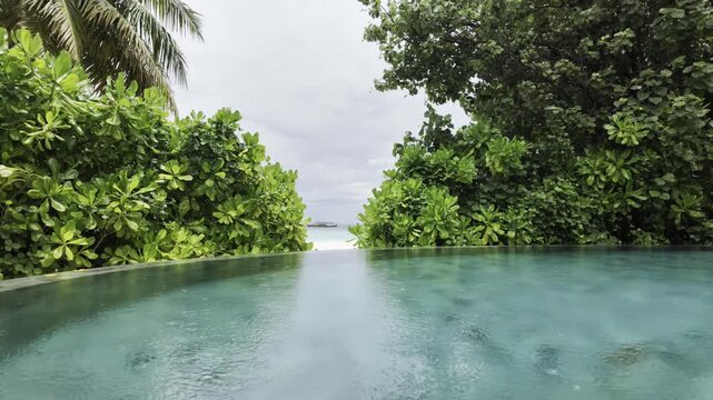 Heavy rain on an infinity pool with tropical plants in the Maldives