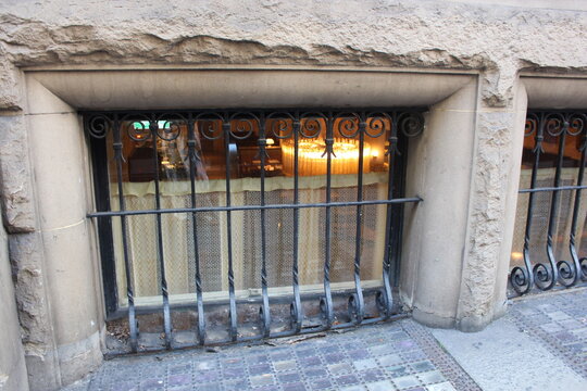 Barred basement window set in rough rusticated sandstone