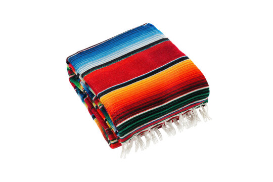 Vibrant, folded Mexican serape blanket with colorful stripes and white fringe is isolated on a clean white background