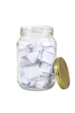 Clear glass jar filled with many folded white paper slips and a golden lid, isolated on a clean white background