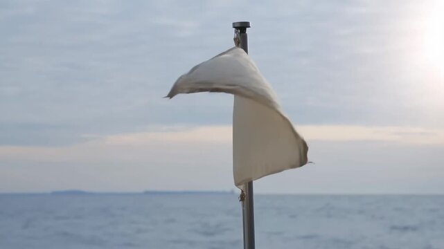 Maritime flag fluttering in the wind beside the open sea and coastal horizon. Maritime travel promotion, coastal tourism advertising, and sailing content.