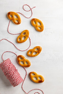 Sweet pretzel cookies with red baker twine on minimal white background for Christmas snack packaging, recipe blog or handmade food branding
