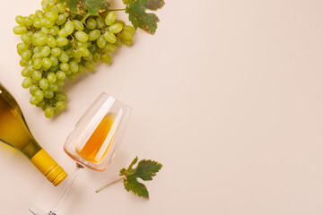 Fototapeta premium White wine glass and green grapes framing pastel copy space