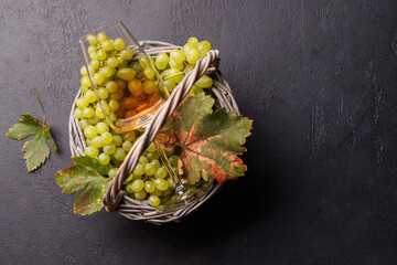Fototapeta premium Wicker basket filled with green grapes and rose wine