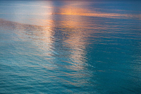 Sunlight reflected in calm water surface in morning