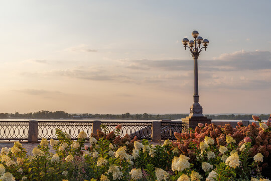 Beautiful riverside promenade with flowers at sunset