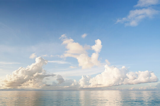 White puffy clouds above calm Caribbean Sea