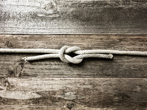 Square knot on wooden surface