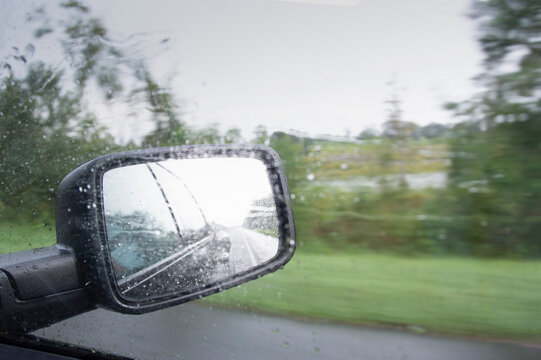 Close-up of truck side mirror in rain storm