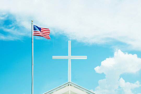 American flag and cross on top of church against sky