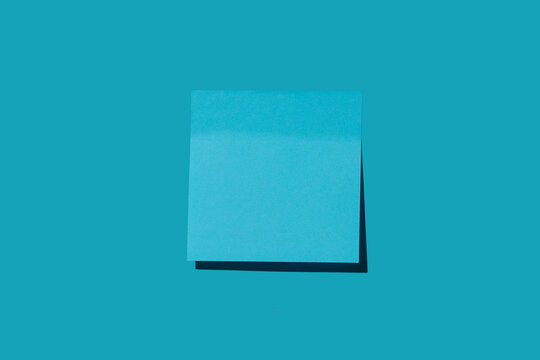 Blank blue post it note on blue background