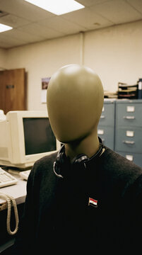 Mannequin head with headphones and Egyptian flag pin