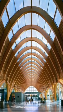 Interior of airport terminal with parabolic timber arches and glass